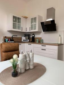 una cucina con armadi bianchi e un tavolo con un vassoio di MEERzeit-Norderney a Norderney