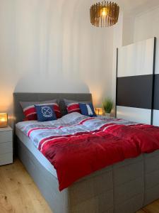 a bedroom with a large bed with red and blue pillows at MEERzeit-Norderney in Norderney