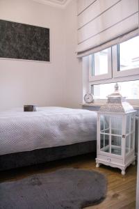 biała sypialnia z łóżkiem i oknem w obiekcie APARTAMENT w CENTRUM-GARAŻ w Kielcach