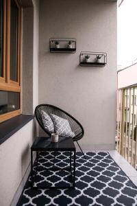 krzesło siedzące na dywanie na patio w obiekcie APARTAMENT w CENTRUM-GARAŻ w Kielcach