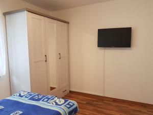 1 dormitorio con 1 cama y TV en la pared en Ferienwohnung- SARAH, en Hahnstätten