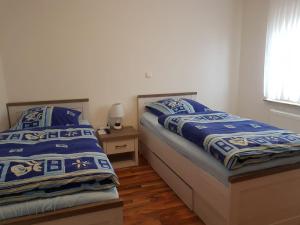um quarto com 2 camas com lençóis azuis e brancos em Ferienwohnung- SARAH em Hahnstätten