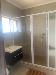 baño con lavabo y ducha con puerta de cristal en Holiday unit 37 Eden dunes, en Shelly Beach