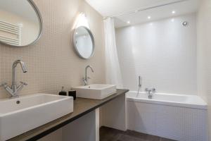 uma casa de banho com um lavatório, uma banheira e um espelho. em NOCNOC - Le Ténor, Monnaie em Lille