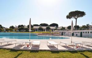 a swimming pool with lounge chairs and a building at Vila Bicuda Resort in Cascais