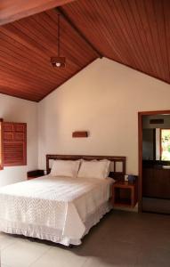 ein Schlafzimmer mit einem Bett und einer Holzdecke in der Unterkunft Pousada Flor Nativa in Brejetuba