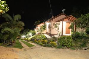 a house with lights on the side of it at night at Pousada Flor Nativa in Brejetuba