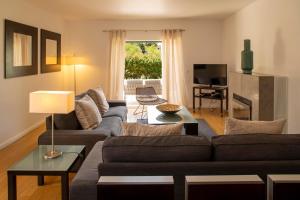 a living room with a couch and a tv at Vila Bicuda Resort in Cascais