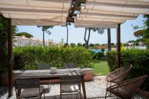 a table and chairs under an umbrella on a patio at Vila Bicuda Resort in Cascais