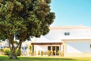 a tree in front of a white building at Vila Bicuda Resort in Cascais