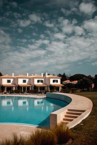 a large swimming pool in front of a house at Vila Bicuda Resort in Cascais