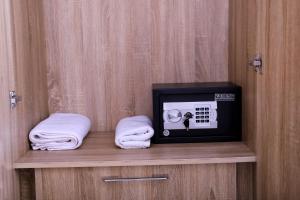 a small television sitting on a shelf with towels at GAZANIA CLASSIC SUITE, RHODABODE APT. in Abuja