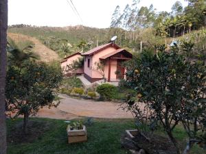 ein Haus mit einem Orangenbaum davor in der Unterkunft Pousada Flor Nativa in Brejetuba