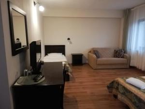 ein Wohnzimmer mit einem Schreibtisch und einem Sofa in der Unterkunft Complexul Turistic Cheile Butii in Cîmpu lui Neag