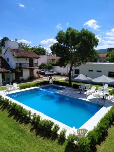 a pool with chairs and umbrellas in a yard at Posada de los Poetas Hotel Boutique in San Lorenzo