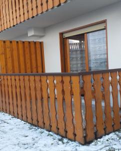 a wooden fence in the snow with a window at Le coeur des Memises in Thollon