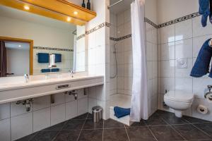 W łazience znajduje się umywalka, toaleta i lustro. w obiekcie CAESARO Hotel & Pizzeria - 20 Jahre Familienunternehmen w mieście Hagen