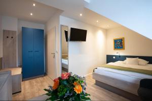 sypialnia z łóżkiem i wazonem kwiatów w obiekcie CAESARO Hotel & Pizzeria - 20 Jahre Familienunternehmen w mieście Hagen