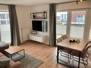 ein Wohnzimmer mit einem Tisch und einem TV. in der Unterkunft Ferienwohnung Hohe Lith in Cuxhaven