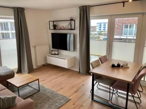 sala de estar con mesa y TV. en Ferienwohnung Hohe Lith en Cuxhaven