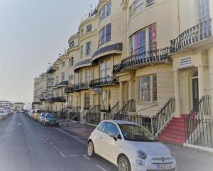 a small white car parked in front of a building at The West Pier Residence in Brighton & Hove