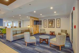 
a living room filled with furniture and a table at Holiday Inn Express Hotel & Suites Gulf Shores, an IHG Hotel in Gulf Shores

