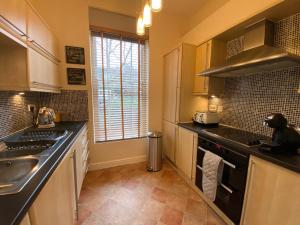 a kitchen with a sink and a stove top oven at Fabulous 2 bed Ground floor apartment Belper in Belper