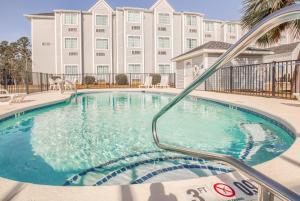 a swimming pool in front of a large building at Microtel Inn & Suites by Wyndham Gulf Shores in Gulf Shores