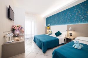 A bed or beds in a room at Viva Beach Hotel