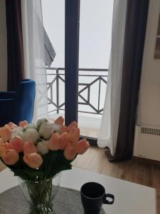 un jarrón de flores sentado en una mesa con una ventana en Magic View E16 Kopaonik, en Kopaonik