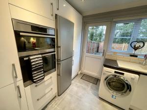 a kitchen with a washing machine and a washer and dryer at Walsingham House - Modern 2 Bed - Driveway Parking - Marvello Properties in Norwich