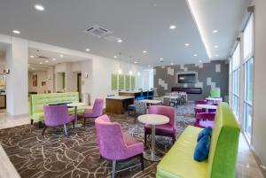 - une salle d'attente avec des chaises et des tables colorées dans l'établissement La Quinta by Wyndham Mobile, à Mobile