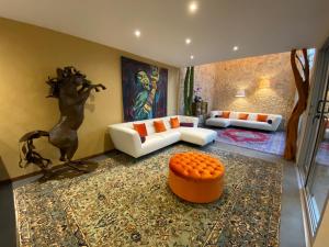 a living room with a white couch and an orange stool at Casarte Boutique Hotel in Playa del Carmen
