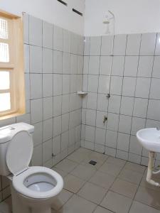 a bathroom with a toilet and a sink at La Guesthouse Étoile in Cotonou