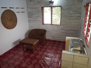 a kitchen with a sink and a chair and a table at La Nouvelle Guesthouse in Cotonou