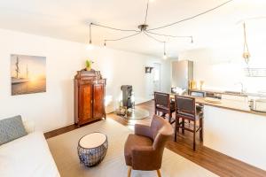 a kitchen and living room with a couch and chairs at Am Borgwallsee 1 in Negast