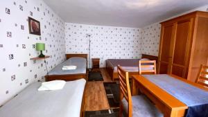 Cette chambre comprend 2 lits et une table. dans l'établissement Fehérház Alkalmi Szálló, à Pécs