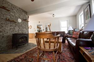 a living room with a leather couch and a fireplace at The Notch Hostel in North Woodstock