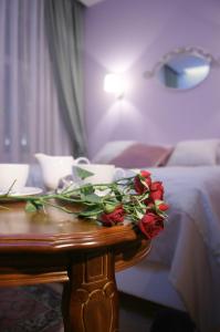 una mesa con rosas en una habitación de hotel en Hotel Lota, en San Petersburgo