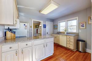 a large kitchen with white cabinets and a refrigerator at Belltown Retreat in Stamford
