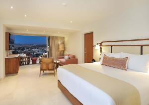 a hotel room with a bed and a living room at Coraz&oacute;n Cabo, a Noble House Resort in Cabo San Lucas