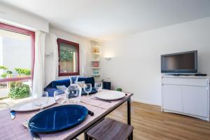 a dining room with a table and a television at Appartement plage Benoit, 80m de la mer, jardinet in La Baule