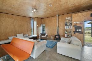 sala de estar con 2 sofás y chimenea en Tranquilo - Waikawa Beach Holiday Home, en Manakau