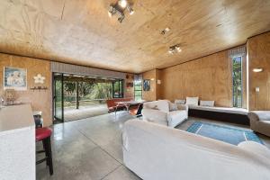 a living room with a couch and a table at Tranquilo - Waikawa Beach Holiday Home in Manakau