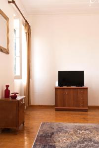 a living room with a flat screen tv on a cabinet at Archontiko ''Danae'' in Lefkimmi