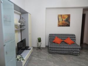 レトイアンニにあるCasa Vacanze Nonna Teresaのリビングルーム(黒と白の椅子、オレンジの枕付)