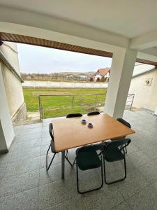 a table and chairs with a view of a field at Vila Nei in Lugoj