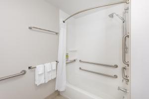 a bathroom with a shower and a bathtub with towels at Holiday Inn Express & Suites - Ottawa, an IHG Hotel in Ottawa
