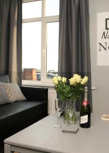 a living room with a table with a bottle of wine and flowers at Twizell Lane in Beamish