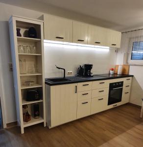 a kitchen with white cabinets and a black counter top at Am Borgwallsee 2 in Steinhagen